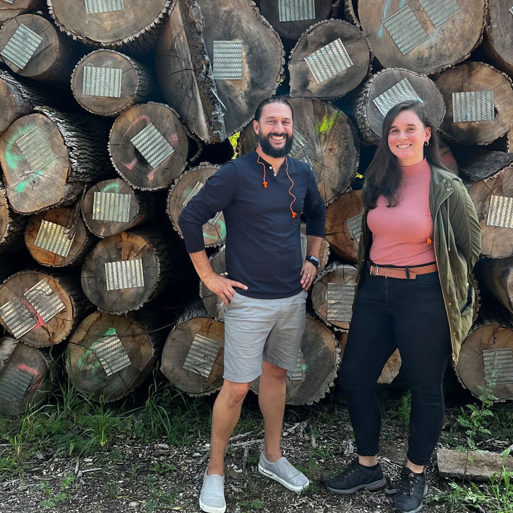 Urban Evolutions Employees In Front Of Urban Tree Logs